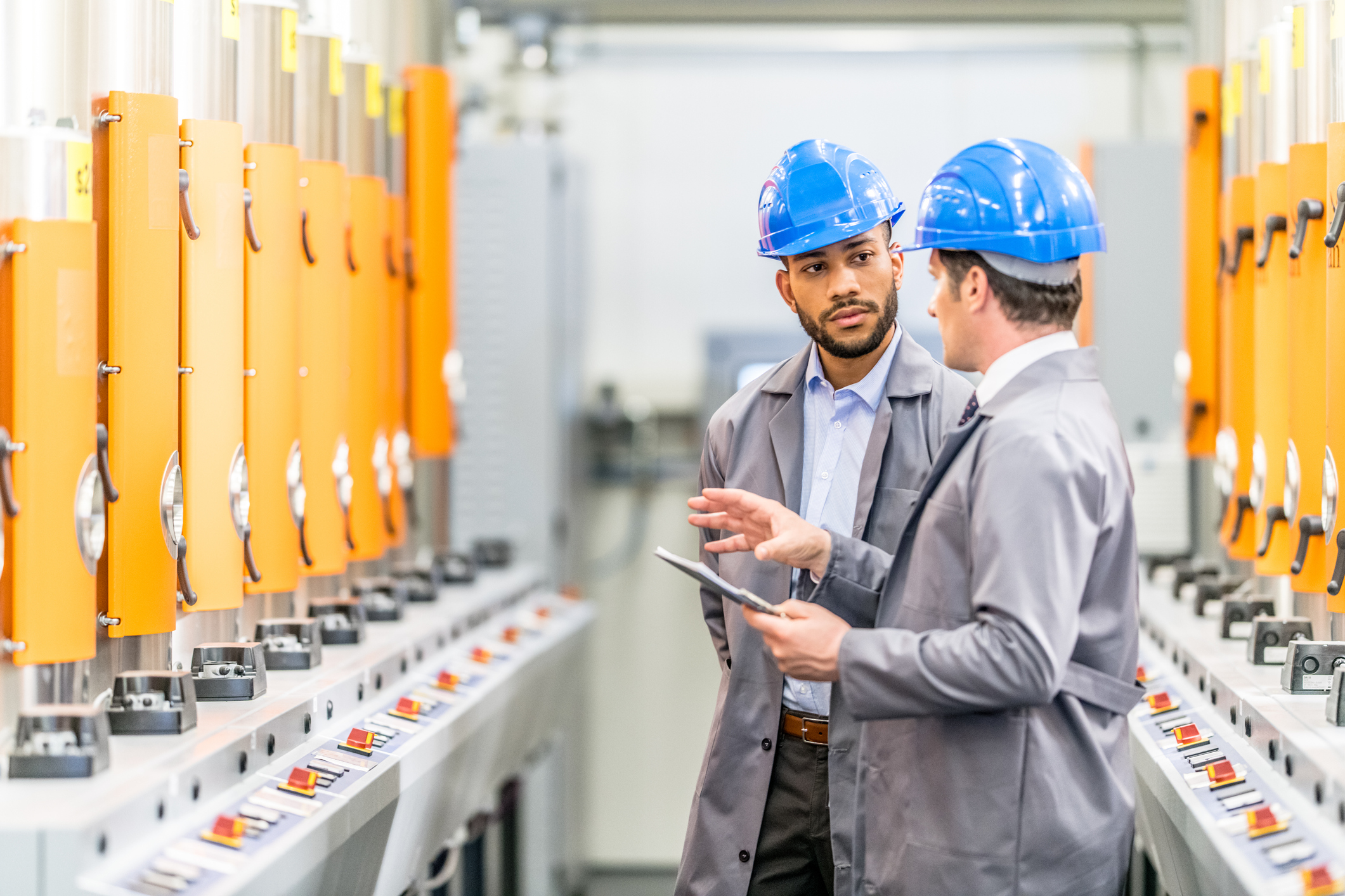 Engineers talking while inspecting machinery
